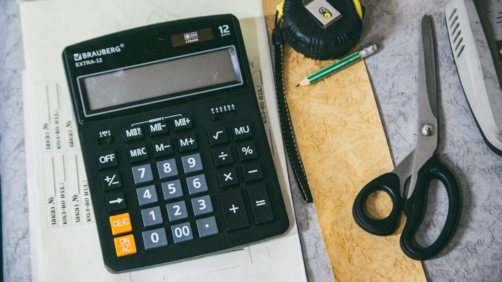Calculadora y material de oficina sobre un escritorio para calcular los intereses de una tarjeta de crédito