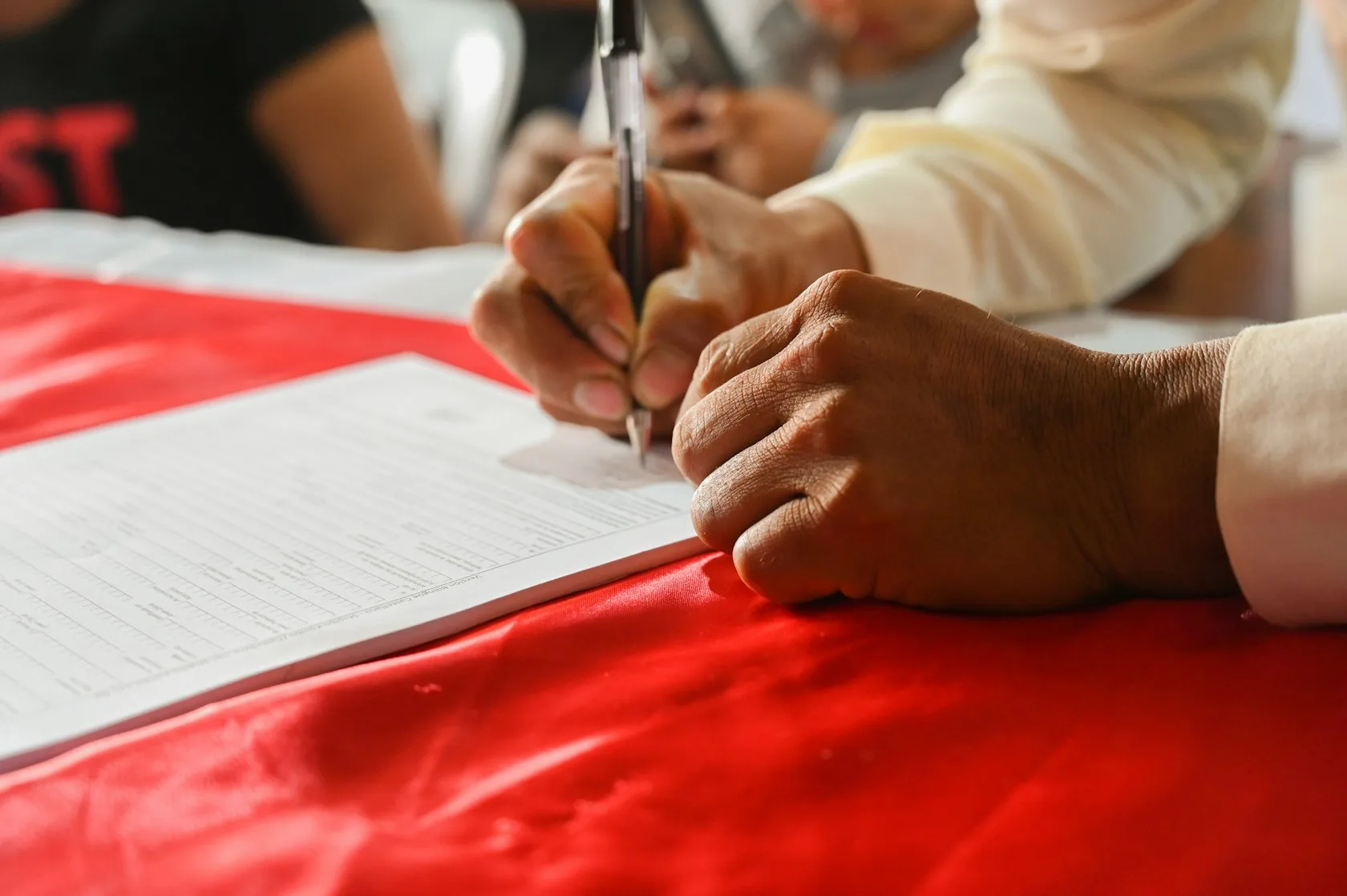 Mano firmando un documento sobre una mesa, imagen sobre la cesión de deuda a un fondo y los derechos del deudor