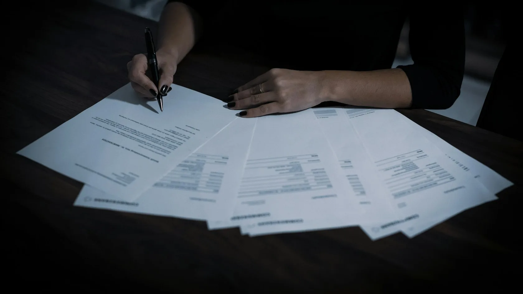 Mujer revisando documentos y papeles sobre una mesa para organizar la hipoteca y las deudas tras un divorcio