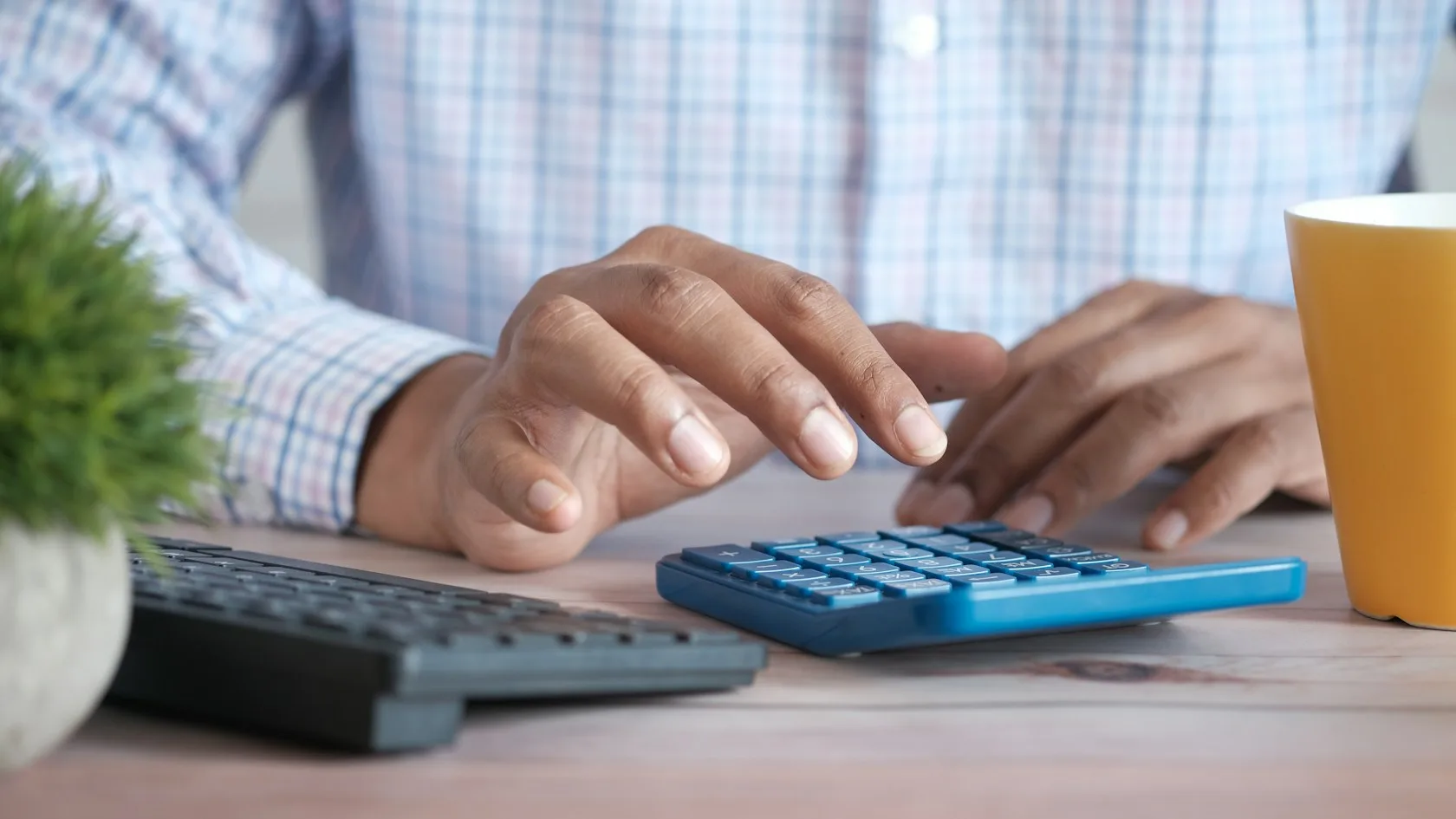 Manos usando una calculadora sobre un escritorio para revisar el saldo de una cuenta embargada