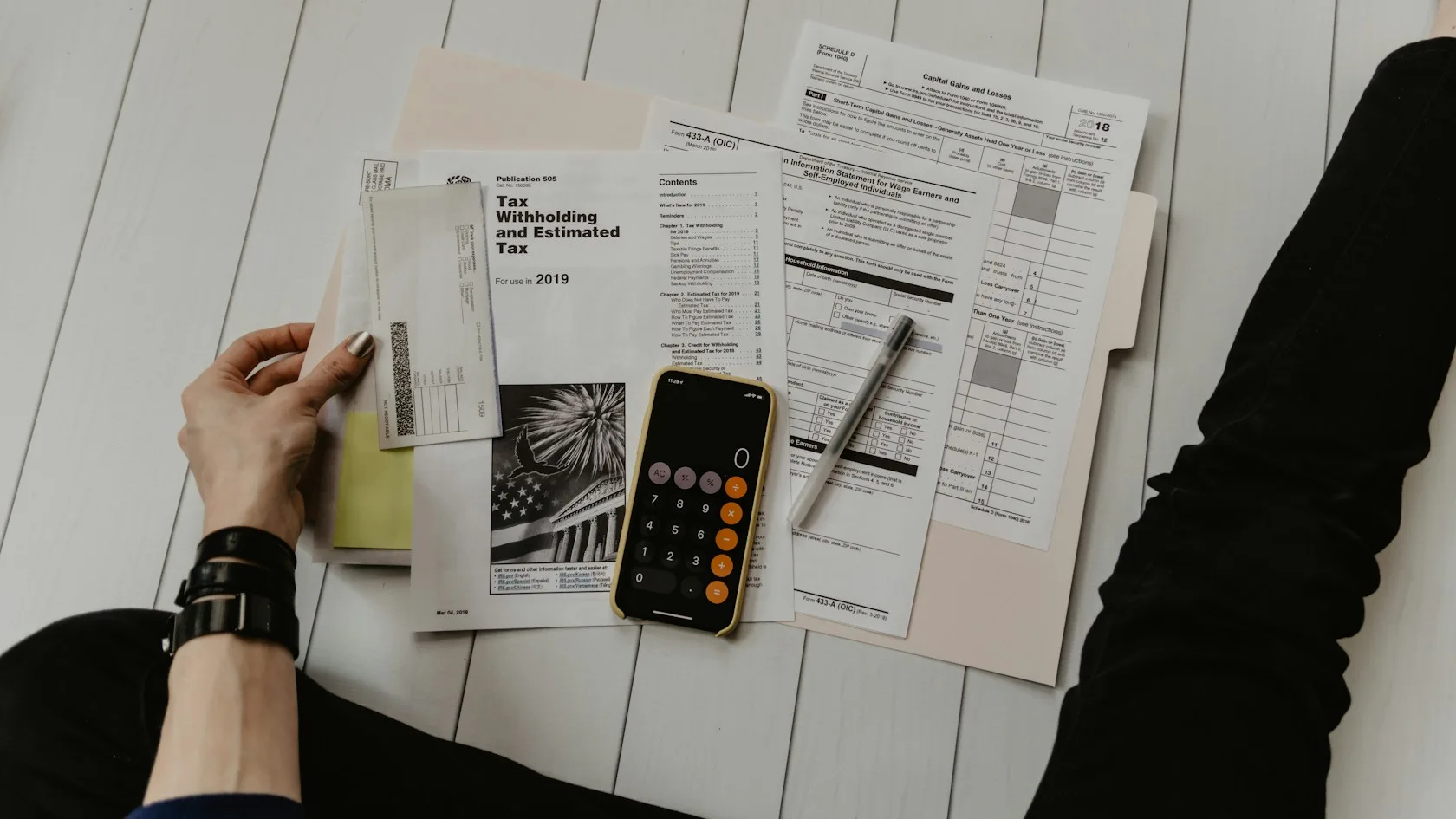 Persona con papeles, bolígrafo y calculadora para revisar la cuota de una hipoteca variable con el euríbor