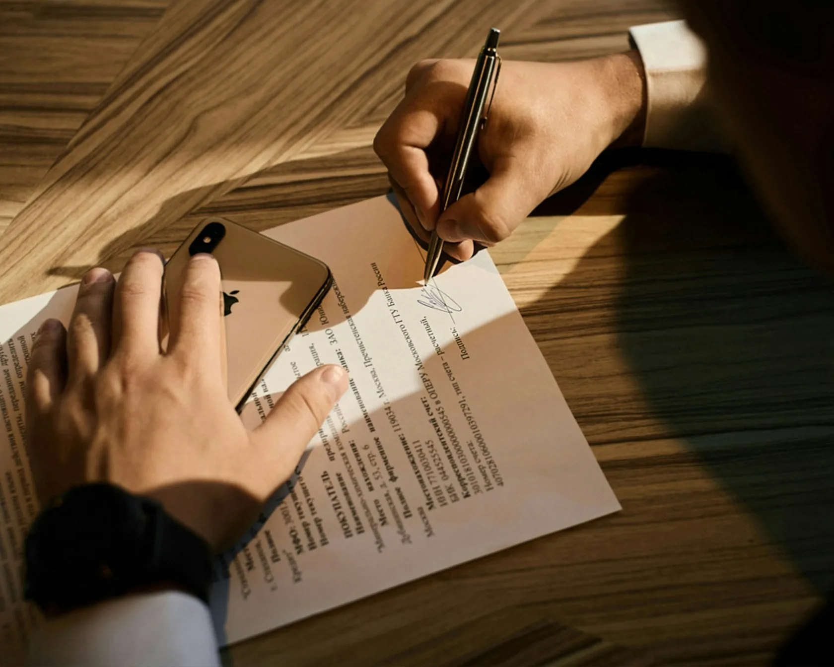 Mano firmando un contrato de préstamo: reclamar intereses de una cláusula abusiva
