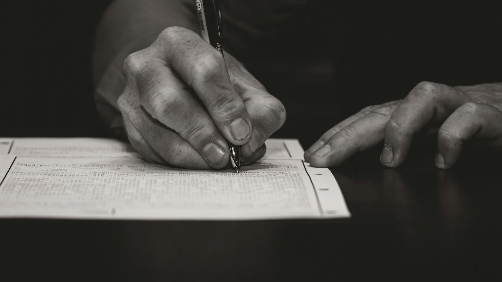 Mano firmando un contrato de préstamo con pluma estilográfica: seguro financiado e intereses en el crédito al consumo