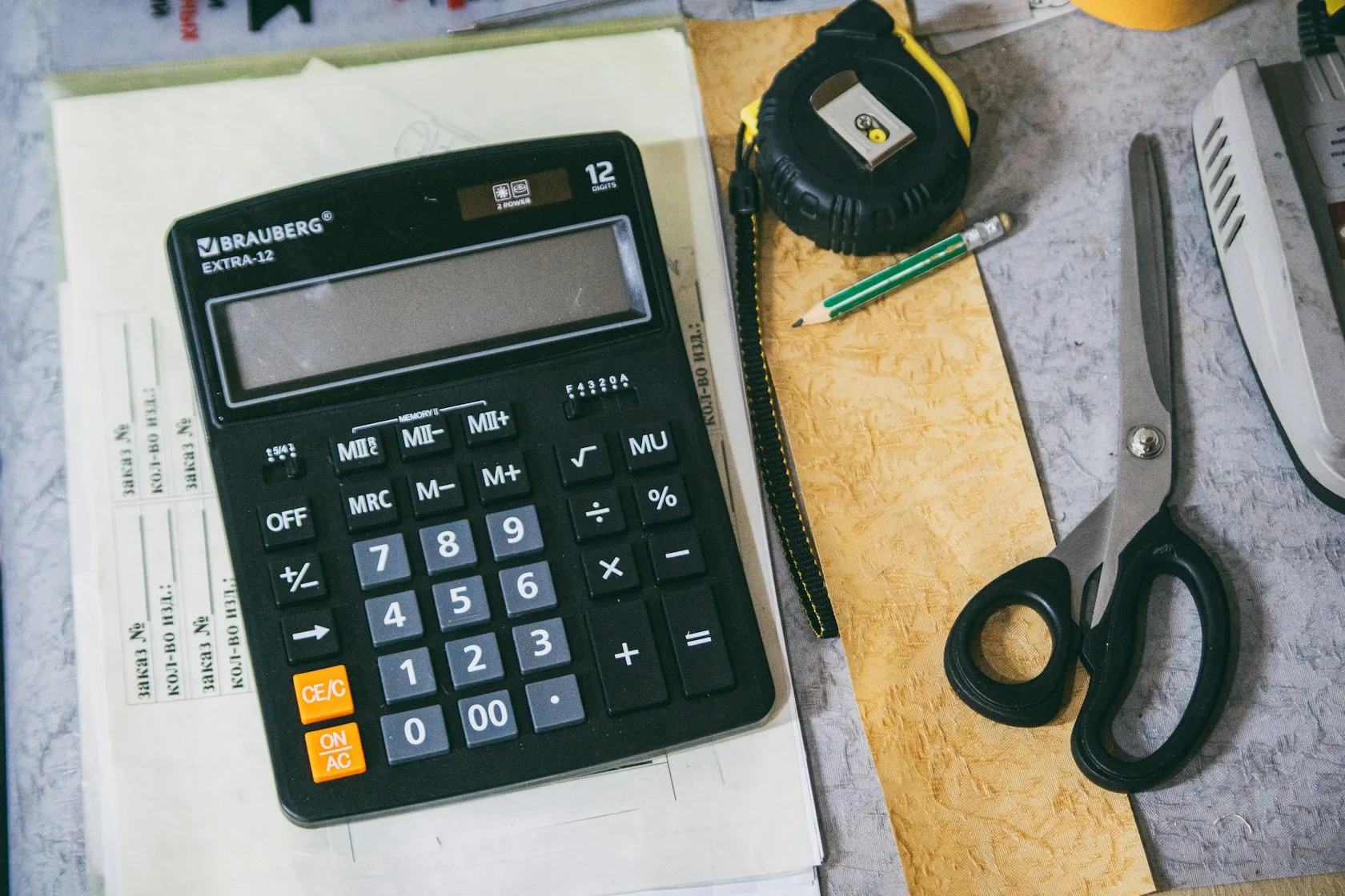 Calculadora y material de oficina sobre un escritorio para calcular los intereses de demora de una hipoteca