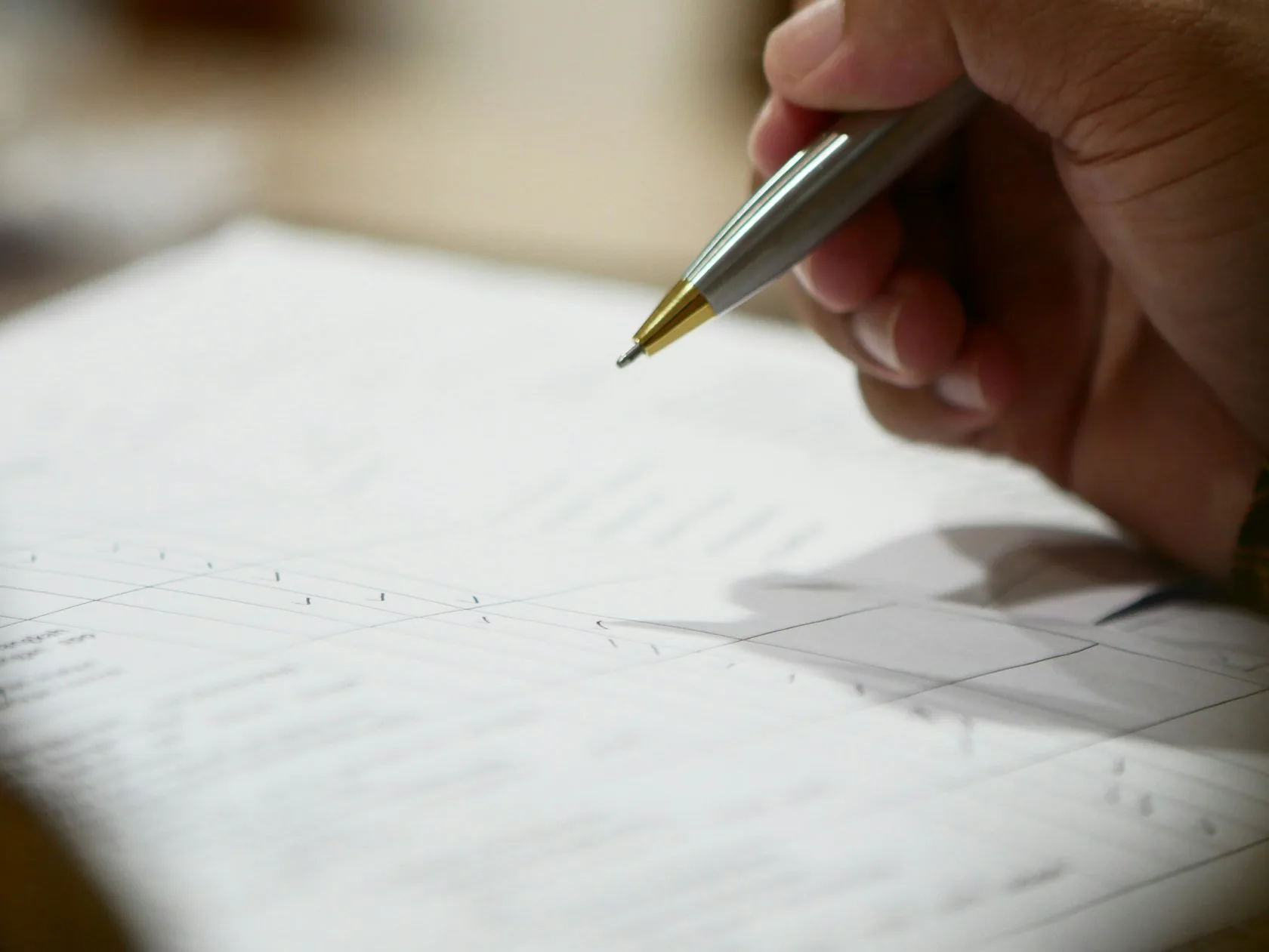 Mano sosteniendo un bolígrafo sobre documentos para calcular el plazo de la Ley de Segunda Oportunidad